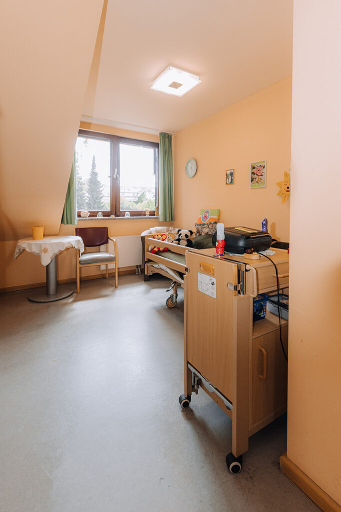 Wohnheim - Blick in Zimmer mit Bett und Sitzmöglichkeit