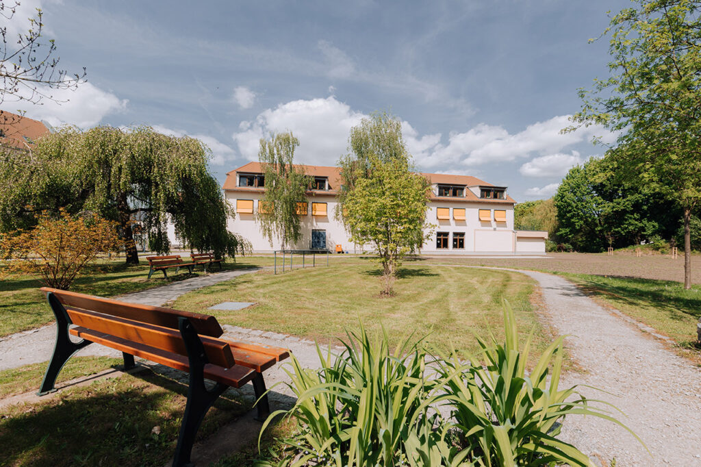 Haus Seidau 3 - begrünte Gartenanlage mit Bänken und schattenspendenden Bäumen
